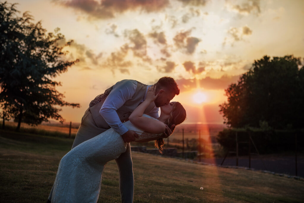 Sunset photography of beautiful couple kissing on their wedding day